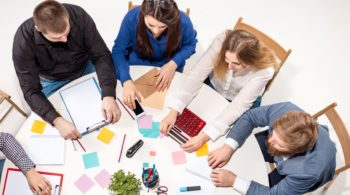 team-sitting-desk-checking-reports-talking-top-view-business-concept-collaboration-team-work-meeting